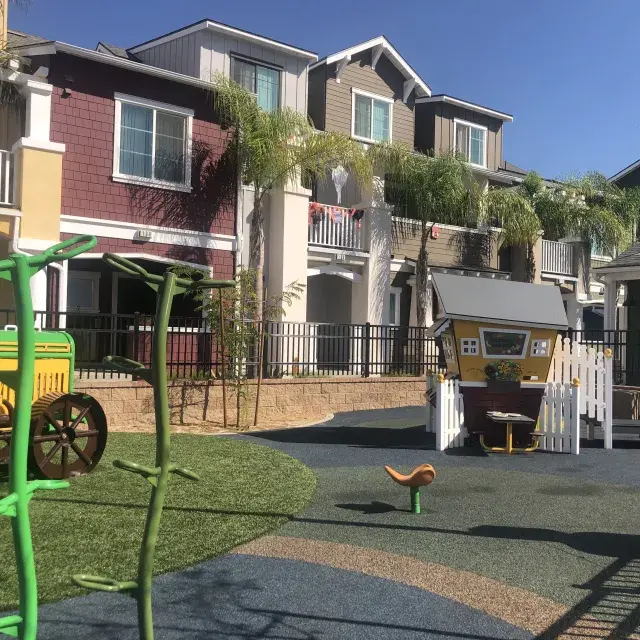 A playground in front of an apartment building