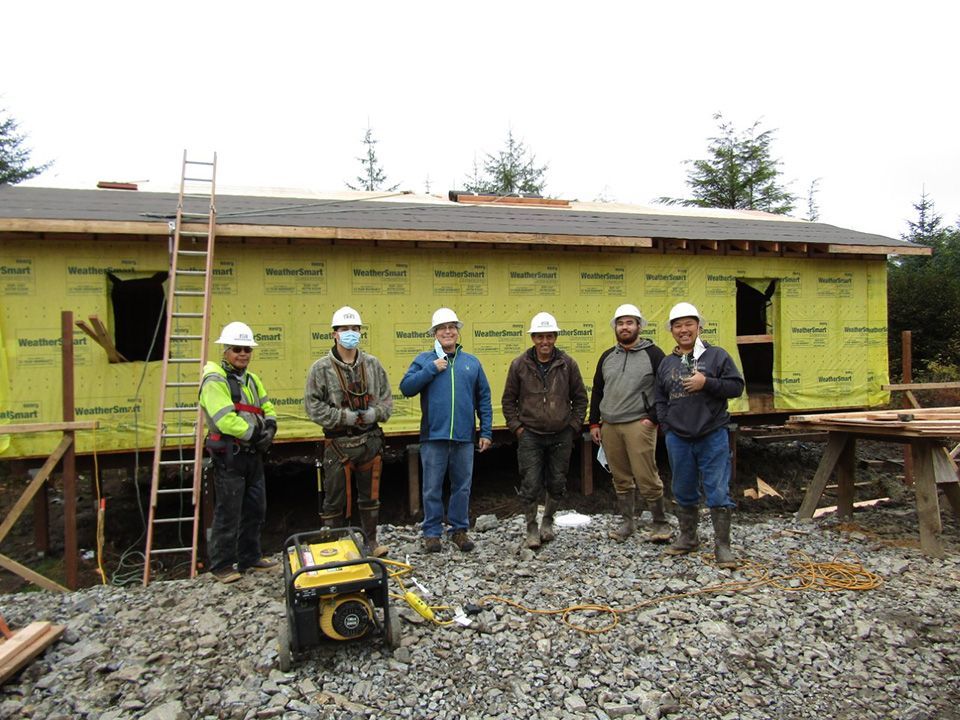 Construction workers standing in front of a home they are building