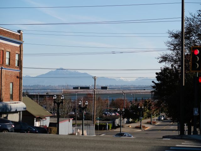 Building and trees on a street with mountains in the background